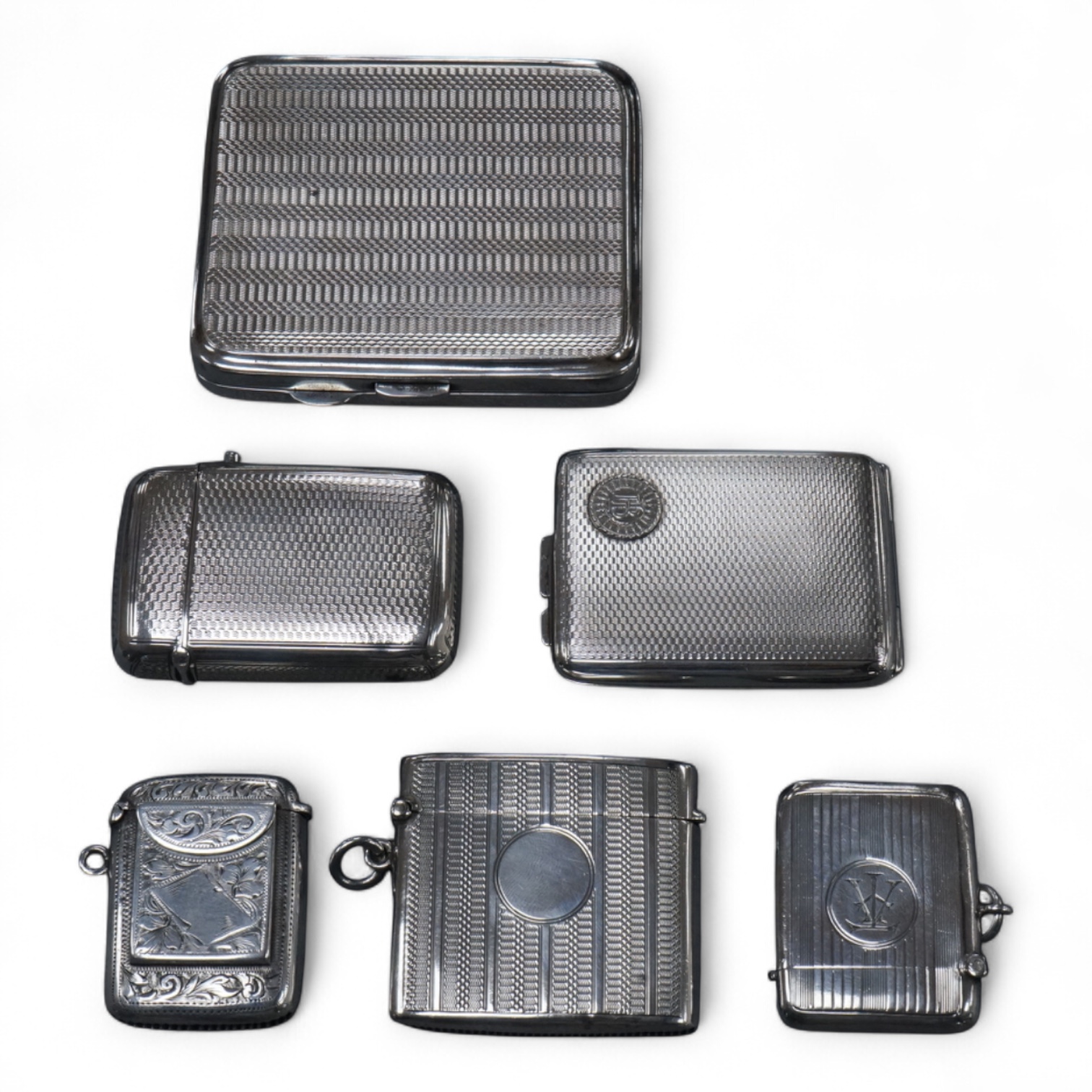 Four assorted early 20th century silver vesta cases including one with a stamp compartment, containing a penny red, maker William Light, Birmingham, 1906, 42mm, together with a silver cigarette case and a silver match sl